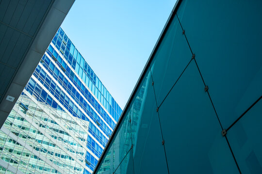 Angular glass facades in Vienna Austria create abstract architecture beneath blue sky where reflections shape the glass facades and angular architecture