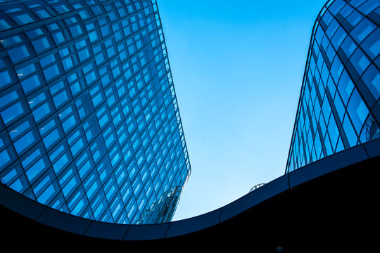 Curved blue glass facades in Vienna Austria create abstract architecture where geometric reflections move across the curved glass facades
