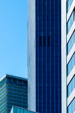 Blue tower facade and glass buildings in Vienna Austria create a vertical urban composition where the tower and buildings rise across the blue facade