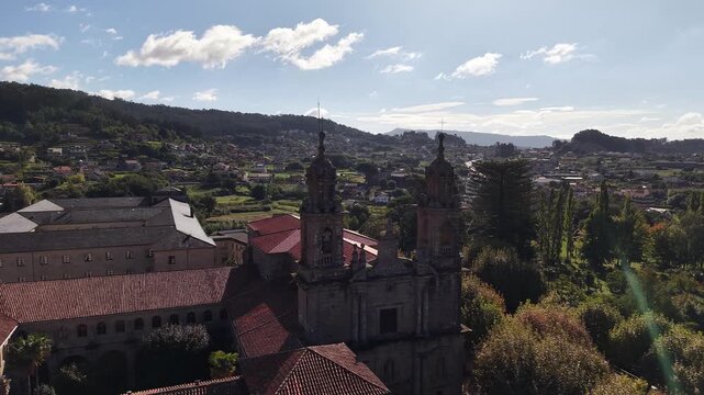 Historic poio monastery building standing among vineyards and green hills of galicia