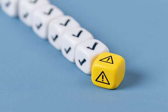 The Warning Dice: Row of Checkmark Cubes and Yellow Hazard Symbols