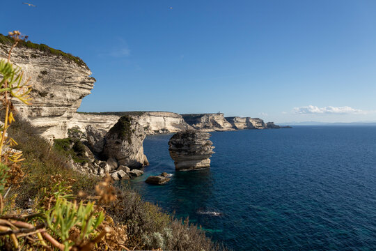 Dramatic view of the famous Grain de Sable stack rock formation standing isolated near the towering white limestone cliffs and coast of Bonifacio, Southern Corsica, France stock photography.
