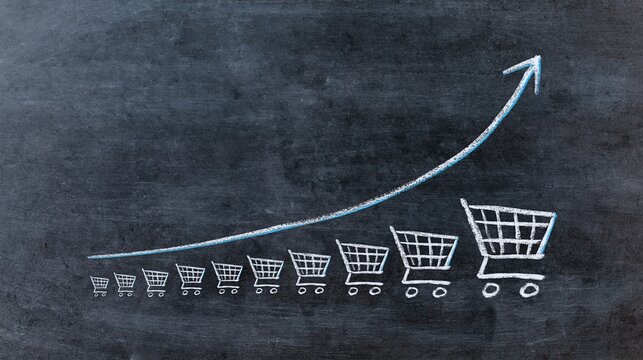 Chalk-drawn exponential growth graph with shopping carts on a dark textured blackboard