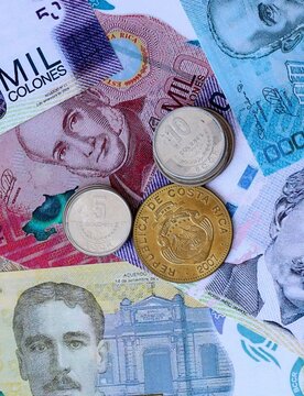 Costa Rican colon money notes and coins on table. Costa Rica cash bills of CRC currency close up