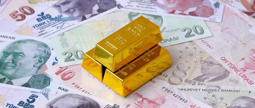 Turkish lira money bills and gold bullion bars. Turkey cash bills of TRY currency close up