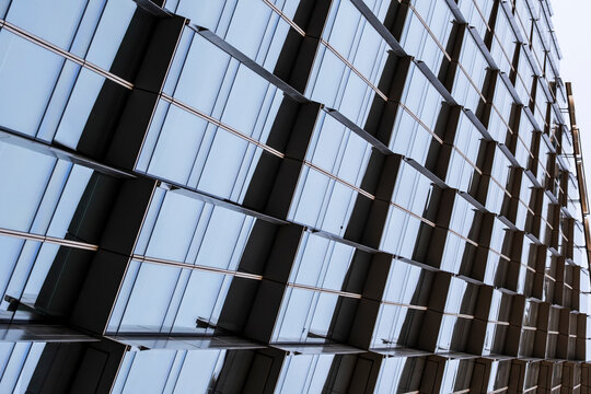 Repetitive metallic facade panels create abstract architecture where pattern perspective and geometric rhythm repeat across the metallic facade panels