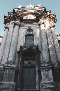 Catholic cathedral in Lviv, Uraine. Majestic church facade on blue sky background. Religious architecture. Ancient stone dome in sunlight. Religion concept. Closed door to the cathedral. 