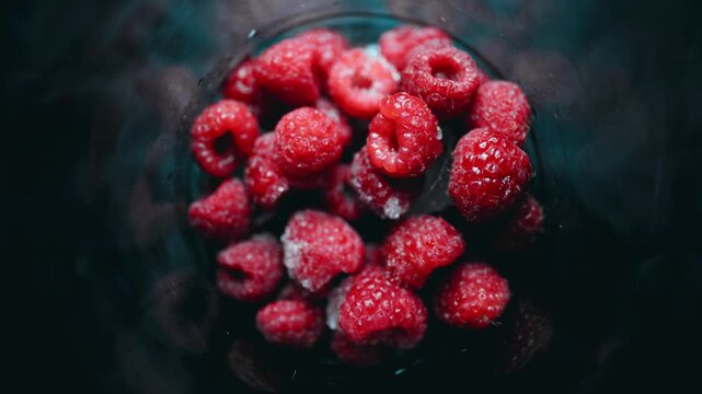 Fresh raspberries freezing in a glass in time lapse. Healthy berries and frozen food concept