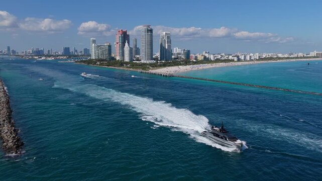 Luxury skyscraper in Miami south beach. Motorboat at sea. Landscape of Miami south beach. Yacht at sea. Aerial view on luxury charter yacht. Landscape aerial with Miami skyscraper. Sea travel