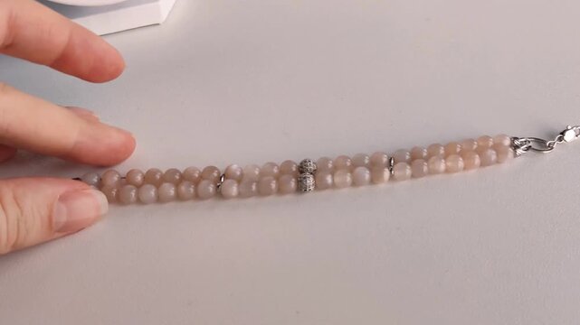 Elegant layered multi strand bracelet featuring polished natural sunstone gemstone beads, shiny silver chain links, metallic clasps, and decorative metal findings on a clean white surface