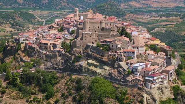 Santa Severina Calabria Italy 4k drone 70mm view of medieval Norman castle. Telephoto flyover over hilltop borgo village and castle ending at steep valley cliff. most beautiful italian villages 