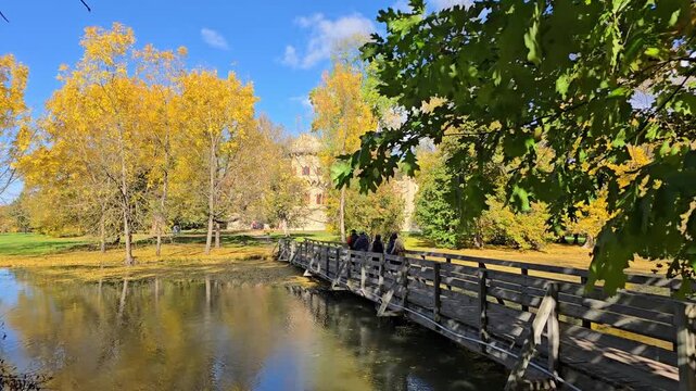 Wooden footbridge across lake in autumn park of Lednice Castle