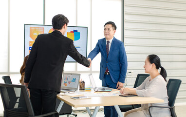 Asian business partnership meeting greeting handshake conversation project success marketing workgroup discussing growth ideas information communication company professional teamwork collaboration. © Bangkok Click Studio