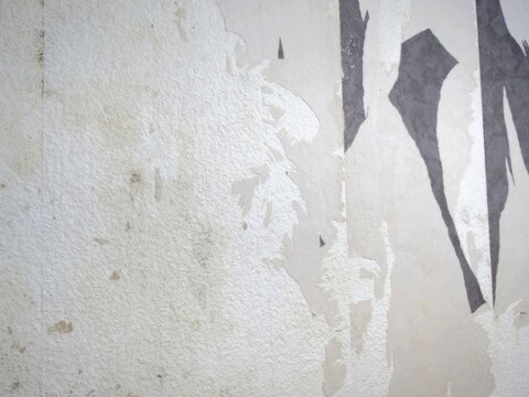 Torn Old Wallpaper on Textured White Interior Wall During Home Renovation Project, Abstract Vintage Paper Layer Peel Surface Background, Damaged Plaster Wall Texture with Peeling Paper and Glue Stains