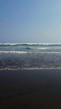 Parangtritis Beach faces the Indian Ocean, featuring vast ocean waves and a wide stretch of sandy beach along the southern coast of Yogyakarta, Indonesia. The expansive sea, rolling waves.
