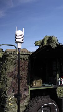 Vertical screen Camouflaged military vehicle with communication antenna and open equipment compartment designed for field operations tactical communications and mobile command use