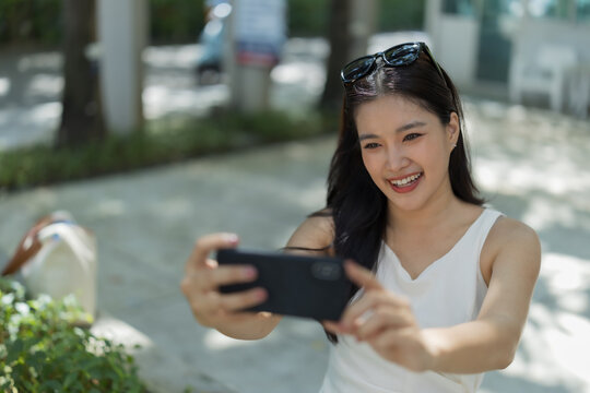 Young woman taking selfie outdoors, sharing moments, enjoying travel and leisure