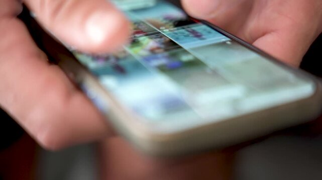 close up of hands doing infinite scrolling on mobile phone, concept of phone and social media addiction, doom scrolling