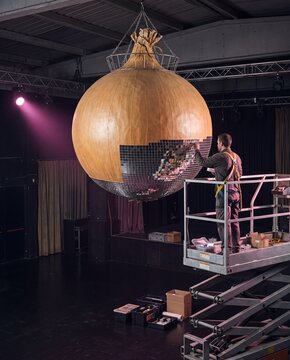 Giant Onion Disco Ball. Technician installing it on stage