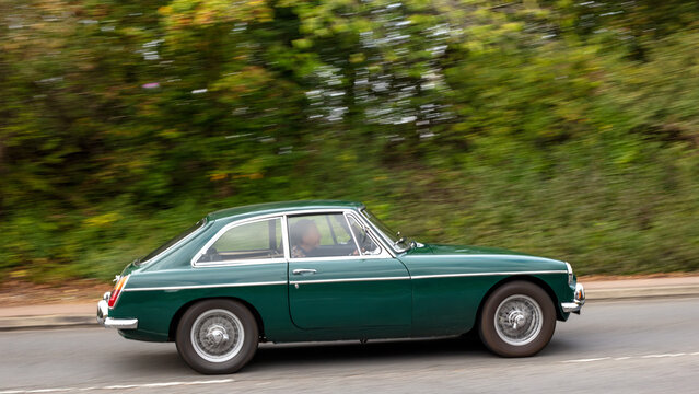 Milton Keynes; UK - Sept. 27th 2026: 1967 green MG B GT classic car driving on a British road