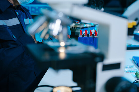 Engineer testing BMS circuit board voltage with a multimeter, checking lithium battery cells for precision, safety, diagnostics, maintenance and energy technology.
