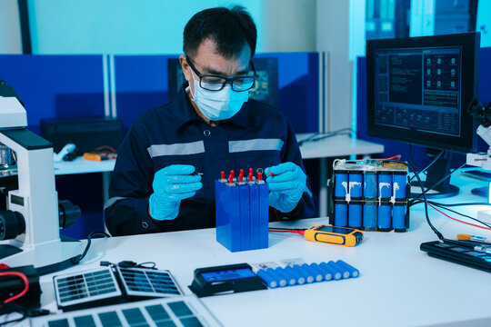Engineer testing a battery pack with a multimeter in a high-tech lab, exploring BMS, renewable energy storage, electrical testing, clean power, and battery innovation.