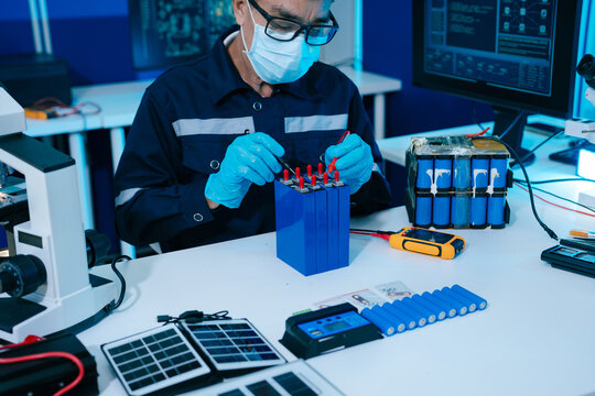Engineer testing a battery pack with a multimeter in a high-tech lab, exploring BMS, renewable energy storage, electrical testing, clean power, and battery innovation.