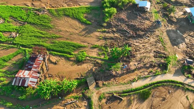 Aerial view captures muddy debris left by violent flash floods, revealing damaged rice paddies, eroded farmland, sediment deposits, and threats to rural livelihoods. Nan Province, Thailand. 4k.
