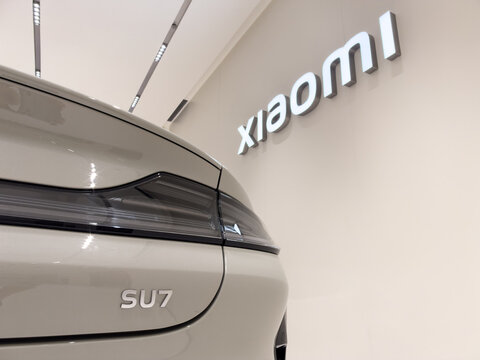 Shenzhen, China - September 21, 2026: Xiaomi SU7 rear badge close up beside XIAOMI wall logo