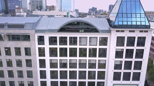 Aerial drone footage of a building with unique, interesting architecture in the city center, business district in the inner city, Innenstadt in Frankfurt am Main, Hesse, Germany in the European Union.
