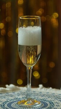 Vertical video. Celebrating New Year or birthday. Person pouring glass of champagne and drinking it at New Year party.