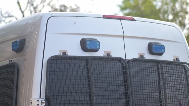 Blue emergency lights flashing on the back of a police van