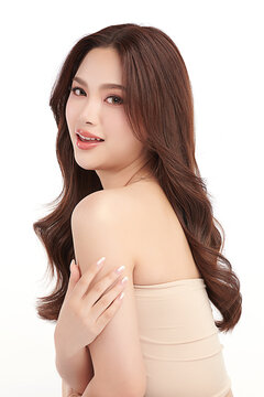 A beautiful young Asian woman with clean, fresh skin against a white background. Skincare, facial treatment, cosmetology, beauty, and spa. An elegant portrait of an Asian woman.
