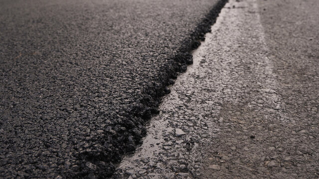 Fresh asphalt layer showing road construction, new pavement, and infrastructure repair with textured surface
