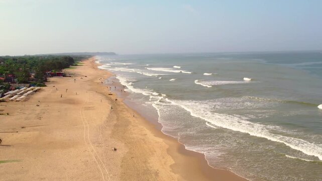 Aerial drone view of vagator beach in goa india with people walking