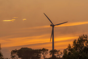 Wind turbine silhouette against a golden sunset sky viewed from Trehøje, Denmark © LeonHansenPhoto