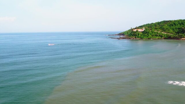 Aerial view of baga beach in goa india with a small boat sailing on