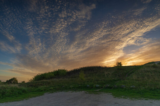 Dramatic sunset panorama over the sea and rolling hills from Treh&oslash;je in Mols Bjerge, Denmark