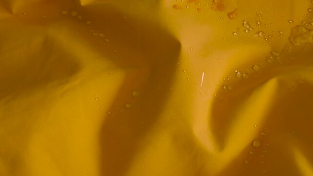 Drops of water are dripping on vibrant yellow hydrophobic fabric surface