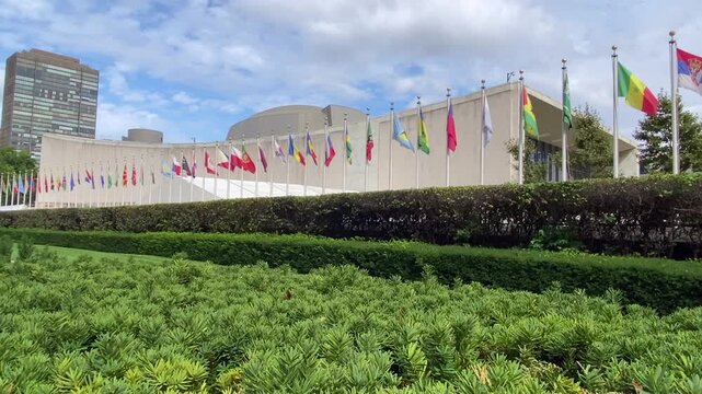 New York, United States: Colorful national flags of United Nations member states flying outside the UN Headquarters in Manhattan, symbolizing international cooperation and diplomacy.