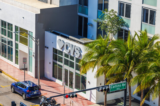 Top view of CVS pharmacy on Collins Avenue with Nissan Rogue, palm trees and traffic lights. Miami Beach. USA. 