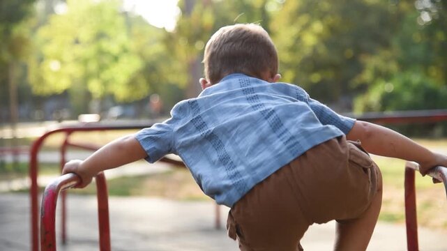 Little boy climbing in playground. Kid jump and play in park at sunny day. Child active outdoor sport in summer. Young children fun happy lifestyle. Aesthetic nature, closeup people, from behind