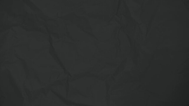 Subdued black crumpled paper texture in a stop motion loop video
