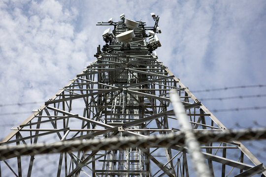 Tall Metal Communication Tower Against Cloudy Sky