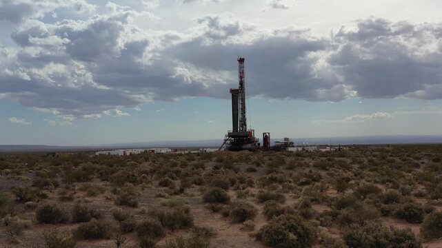 A smooth, lateral aerial drone shot shows an active oil drilling rig operating in the Vaca Muerta shale gas formation in Neuqu&eacute;n, Argentina. 4K.