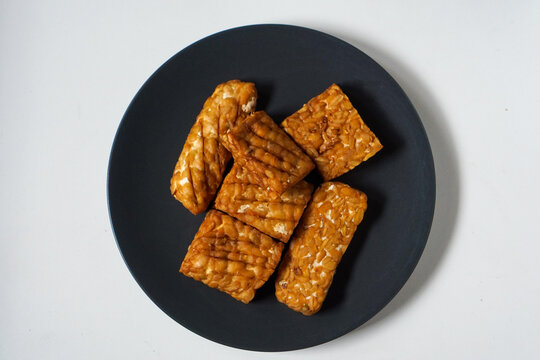 Black plate holds golden-brown tempeh pieces