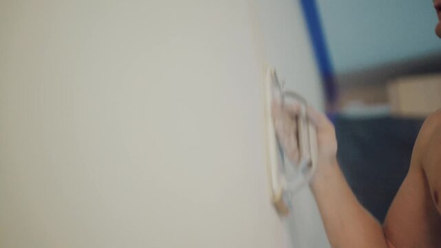 Worker sanding plaster wall with hand sanding float tool, home renovation concept