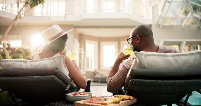 Couple, relax and drink with glasses in spa for weekend, holiday or bonding by swimming pool. Man, woman or relationship with alcohol, snacks or charcuterie board for honeymoon in luxury resort