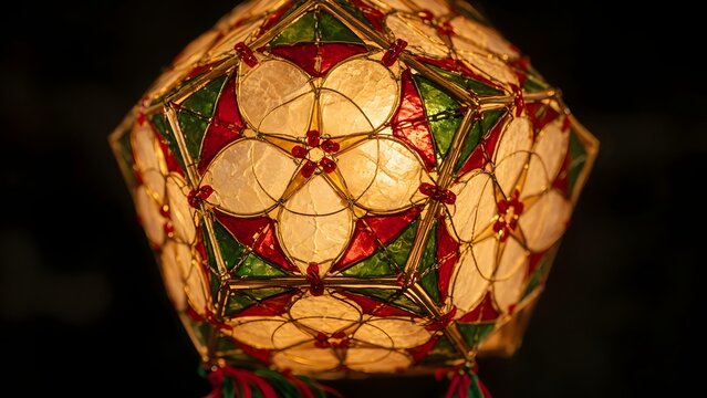 Close-up of a traditional capiz shell parol lantern glowing with warm light through intricate handmade patterns