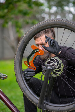 Bicycle Wheel Truing with Orange Caliper Tool and Gloves